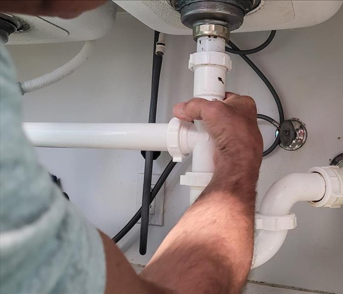 Plumber fitting white pipes together.